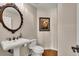 Charming powder room with pedestal sink, decorative mirror, and elegant fixtures at 11 Canon Pl, Greenwood Village, CO 80111