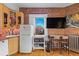 Compact kitchen featuring brick walls, light wood cabinets, and stainless appliances at 1450 N High St # 3, Denver, CO 80218