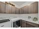 Well-organized laundry room features ample cabinet space, a sink, and modern washer/dryer units at 6728 Mentha Dr, Castle Rock, CO 80108