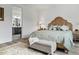 Bright main bedroom featuring an ensuite bath, a light green duvet, and a decorative headboard at 6728 Mentha Dr, Castle Rock, CO 80108