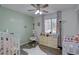 Adorable Bedroom featuring twin cribs, wood-look floors, and a charming green accent wall at 1549 S Evanston St, Aurora, CO 80012