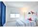 Bright bedroom features a large window, blue curtains, and dinosaur-themed decor at 1641 S Idalia Cir # F, Aurora, CO 80017