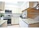Well-equipped kitchen featuring stainless steel appliances, granite countertops, and a view into an adjacent room at 1641 S Idalia Cir # F, Aurora, CO 80017