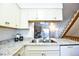 Bright kitchen with granite countertops, white cabinetry, and stainless steel appliances at 1641 S Idalia Cir # F, Aurora, CO 80017