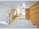 Bright living room with wood accent wall, staircase, and partial view into the kitchen area at 1641 S Idalia Cir # F, Aurora, CO 80017