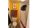 Bathroom with yellow accent wall with framed art, neutral colored shower curtain and towels at 1888 S Jackson St # 404, Denver, CO 80210