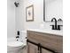 Bathroom with a bathtub, toilet, and vanity with a sliding door cabinet and black fixtures at 7395 E Eastman Ave # 202N, Denver, CO 80231