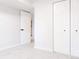 Empty bedroom with white walls, neutral carpet, and double doors, with light streaming through doorway at 7395 E Eastman Ave # 202N, Denver, CO 80231