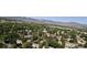 Picturesque aerial view of houses nestled among lush trees, with mountains in the distance at 8960 W Dartmouth Pl, Lakewood, CO 80227