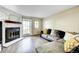 Comfortable living room featuring a fireplace, hardwood floors, and a large window at 8960 W Dartmouth Pl, Lakewood, CO 80227