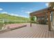 The wooden patio area includes a privacy pergola, white fence, and lush greenery at 17710 E Emilia Dr, Parker, CO 80134