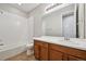 Clean bathroom with a tub and shower combination and a vanity with warm brown cabinetry and a white countertop at 17710 E Emilia Dr, Parker, CO 80134