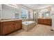 Bright bathroom featuring dual sinks, granite countertops, soaking tub, and glass-enclosed shower at 17710 E Emilia Dr, Parker, CO 80134