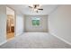 Comfortable bedroom with neutral walls, gray carpeting, and a window with views of a green landscape at 17710 E Emilia Dr, Parker, CO 80134