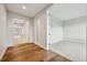 Hallway with hardwood floors leading to a carpeted room with a neutral color palette at 17710 E Emilia Dr, Parker, CO 80134