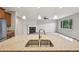 Close up on a kitchen island with a granite countertop overlooking a living room with a fireplace at 17710 E Emilia Dr, Parker, CO 80134