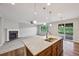 Bright open-concept living area featuring a kitchen island with a fireplace in the carpeted living room at 17710 E Emilia Dr, Parker, CO 80134