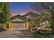 Home exterior showing two car garage, driveway and tree in front at 1933 Chestnut St, Fort Lupton, CO 80621