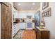 Efficient kitchen with white cabinets, stainless steel refrigerator, and rustic barn door detail at 1933 Chestnut St, Fort Lupton, CO 80621
