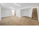 This basement features neutral paint, carpeting, and a staircase at 12063 E Arizona Dr, Aurora, CO 80012