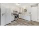 The kitchen features stainless steel appliances, white cabinets and wood flooring at 12063 E Arizona Dr, Aurora, CO 80012