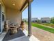 Inviting covered back patio with comfortable seating and a view of the landscaped backyard at 7702 E 157Th Ave, Thornton, CO 80602