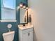 Chic half bathroom boasts modern fixtures, stylish mirror and cute accent lighting at 7702 E 157Th Ave, Thornton, CO 80602