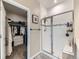 Bright bathroom featuring a glass-enclosed shower with white tile and a glimpse into a walk-in closet at 7702 E 157Th Ave, Thornton, CO 80602