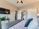 Bedroom featuring neutral walls, ceiling fan, TV, ensuite bathroom, and closet at 7702 E 157Th Ave, Thornton, CO 80602