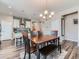 Dining area with a wooden table, stylish chairs, a bench, and a modern light fixture at 7702 E 157Th Ave, Thornton, CO 80602