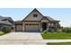 Charming home with a well-maintained lawn, stone accents, and a three-car garage at 7702 E 157Th Ave, Thornton, CO 80602