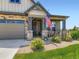 Inviting front porch with rocking chairs, stone pillars, and a well-manicured lawn at 7702 E 157Th Ave, Thornton, CO 80602