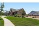 Well-maintained front yard with lush green grass, mature landscaping, and a sidewalk at 7702 E 157Th Ave, Thornton, CO 80602