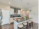 Modern kitchen with white cabinets, striking backsplash, and an island with seating at 7702 E 157Th Ave, Thornton, CO 80602