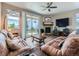 Cozy living room with fireplace, ceiling fan, and sliding glass doors at 7702 E 157Th Ave, Thornton, CO 80602