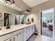 Bright main bathroom featuring double sinks, white cabinetry, and modern lighting at 7702 E 157Th Ave, Thornton, CO 80602