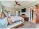 Comfortable bedroom with carpet, a ceiling fan, and a sliding barn door to the bathroom at 7702 E 157Th Ave, Thornton, CO 80602