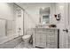 Updated bathroom with a glass-enclosed shower, sleek vanity, decorative mirror and modern black and white flooring at 32 Glenmoor Dr, Englewood, CO 80113