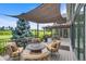 Relaxing outdoor deck with comfortable seating and a shade canopy, offering views of the lush green landscape at 32 Glenmoor Dr, Englewood, CO 80113