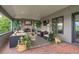 Covered patio boasts an outdoor fireplace, comfortable seating, and golf course views at 32 Glenmoor Dr, Englewood, CO 80113