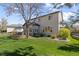 Spacious backyard featuring a well-manicured lawn, mature landscaping, and a stone patio with outdoor seating, perfect for relaxing at 7106 Cerney Cir, Castle Pines, CO 80108