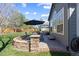 Charming backyard patio area featuring a stone surround, outdoor dining set, and well-maintained lawn, creating a relaxing retreat at 7106 Cerney Cir, Castle Pines, CO 80108