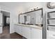 Spacious bathroom featuring double sinks, a large mirror, and wood-look floors at 7106 Cerney Cir, Castle Pines, CO 80108