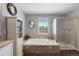 Bright bathroom featuring a soaking tub and a glass-enclosed shower at 7106 Cerney Cir, Castle Pines, CO 80108