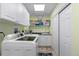 Bright laundry room equipped with a modern washer, dryer, and built-in shelving at 7106 Cerney Cir, Castle Pines, CO 80108