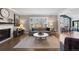 Well-lit living room with hardwood floors, a fireplace, an open layout and seamless flow into the dining area at 7106 Cerney Cir, Castle Pines, CO 80108