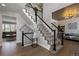Stylish staircase with black and white banisters, carpeted steps, and hardwood floors in the foyer at 7106 Cerney Cir, Castle Pines, CO 80108