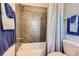 Cozy bathroom featuring a shower over the tub, tiled walls, and decorative towels at 535 Elmhurst Way # A, Highlands Ranch, CO 80129