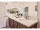 Bathroom with double sinks, wood cabinets, large mirror, and modern fixtures providing a functional and stylish space at 535 Elmhurst Way # A, Highlands Ranch, CO 80129