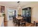 Elegant dining area with stylish light fixture and view to the kitchen; hardwood floors with a dark china cabinet at 535 Elmhurst Way # A, Highlands Ranch, CO 80129